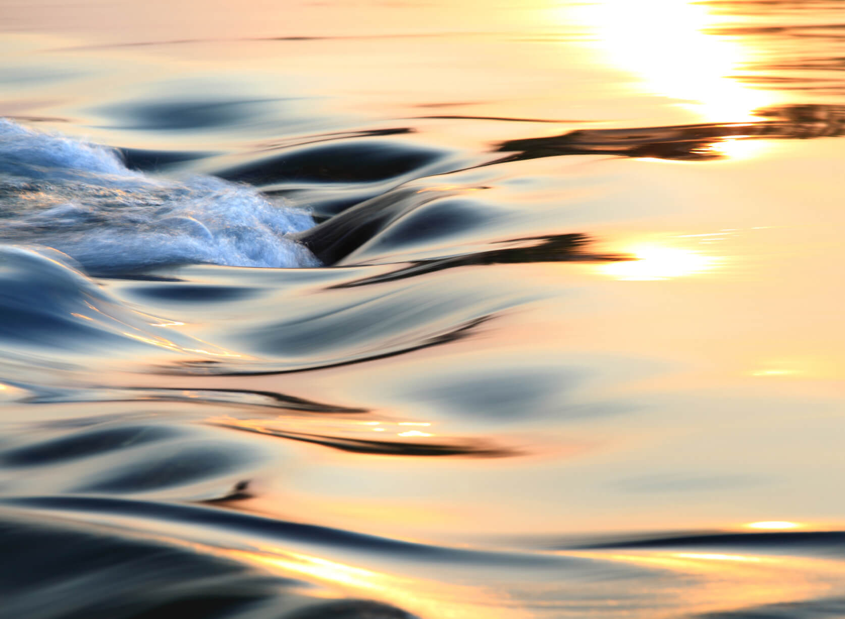 Gentle waves rippling across the surface of a serene river, reflecting the natural beauty of the surrounding environment.